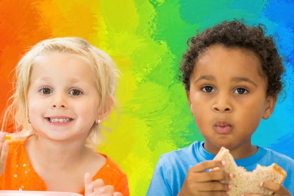 A blonde girl in an orange top smiles while holding a piece of food, and a boy with curly hair in a blue shirt holds a sandwich, against a colorful painted background.