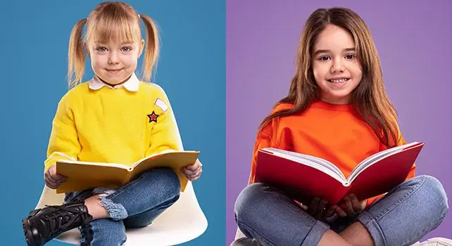 Two girls sit cross-legged on a split blue and purple background, each holding an open book on their lap.