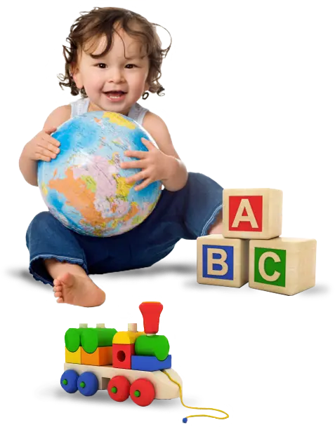 A smiling child sits holding a globe while wooden alphabet blocks and a pull toy train rest nearby.